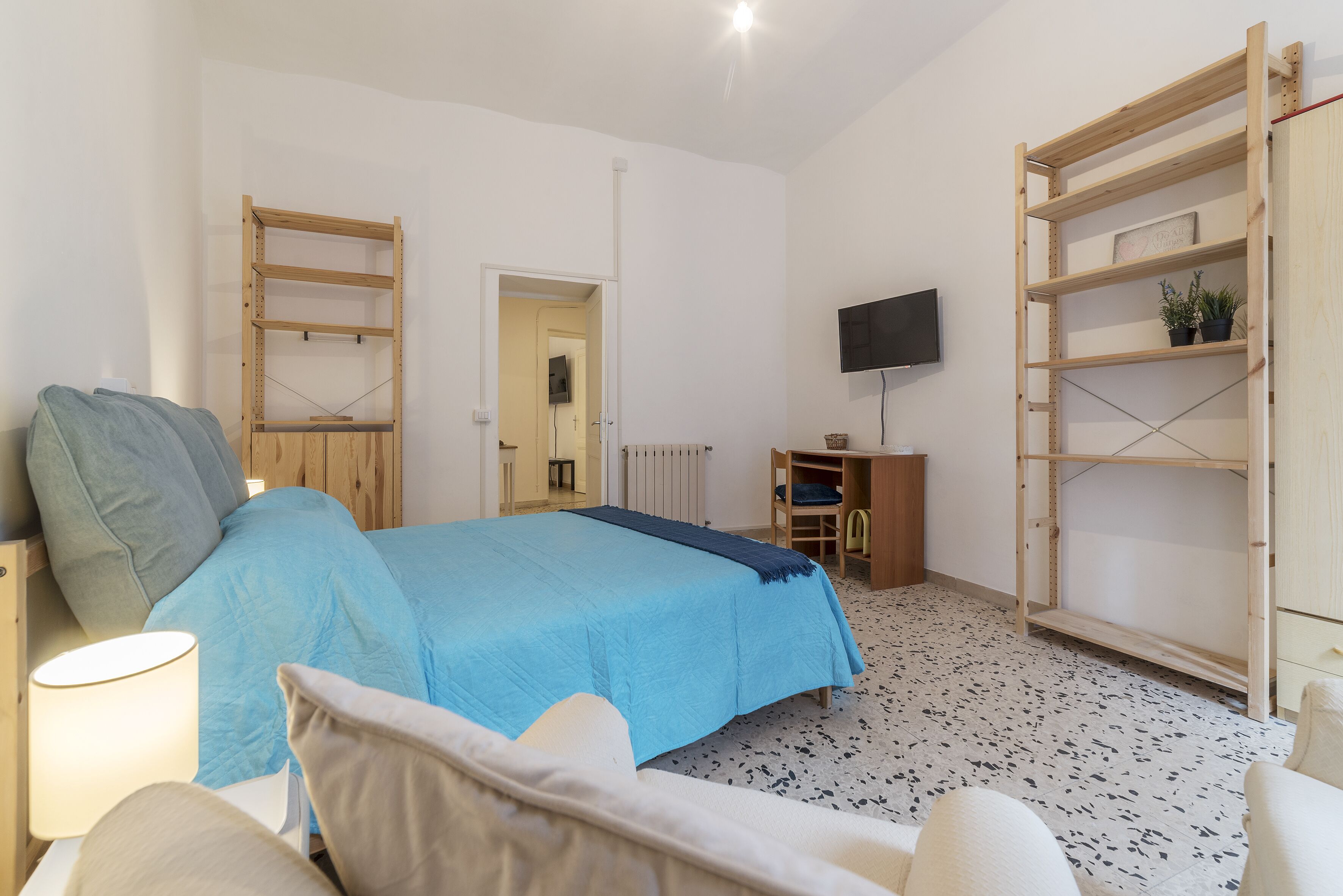 Une chambre à coucher avec un lit, une télévision, une armoire en bois et un bureau.