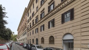 A multi-story building with a row of parked cars along the street. - Villa Albani Apartment (Rome)