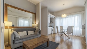 Una sala moderna con sofá, mesa de centro y comedor con sillas y una mesa.