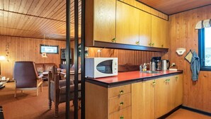 A compact kitchen with wooden cabinets, a microwave, and a coffee maker.