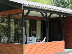 A covered outdoor seating area with a wooden deck and a glass enclosure. - 6 Person Holiday Home in Hals (Hals)