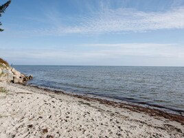A beach with a rocky shoreline and calm sea.