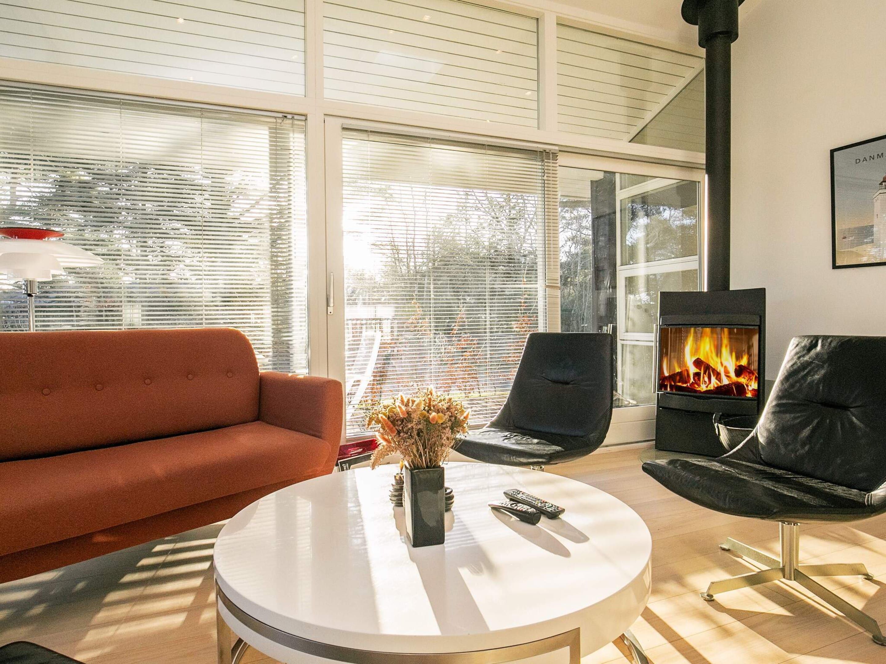 Un salon moderne avec un canapé, une table basse ronde et une cheminée.