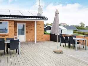A patio with outdoor furniture, a satellite dish, and a brick building.