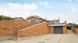 Zona residencial con muro de ladrillo, escalera y garaje.