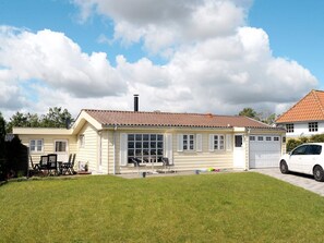 A two-story house with a tiled roof, a garage, and a well-maintained lawn. - 6 Person Holiday Home in Frorup (Frørup)