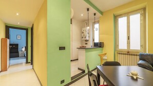 A modern kitchen with a refrigerator, microwave, and sink. - Pigneto Colourful Apartment (Rome)