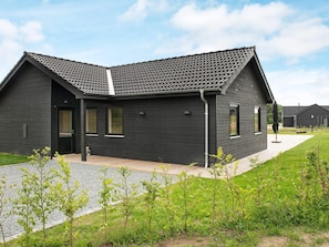 A modern building with a dark exterior, a sloped roof, and a gravel pathway leading to the entrance. - 10 Person Holiday Home in Haderslev-by Traum (Haderslev)