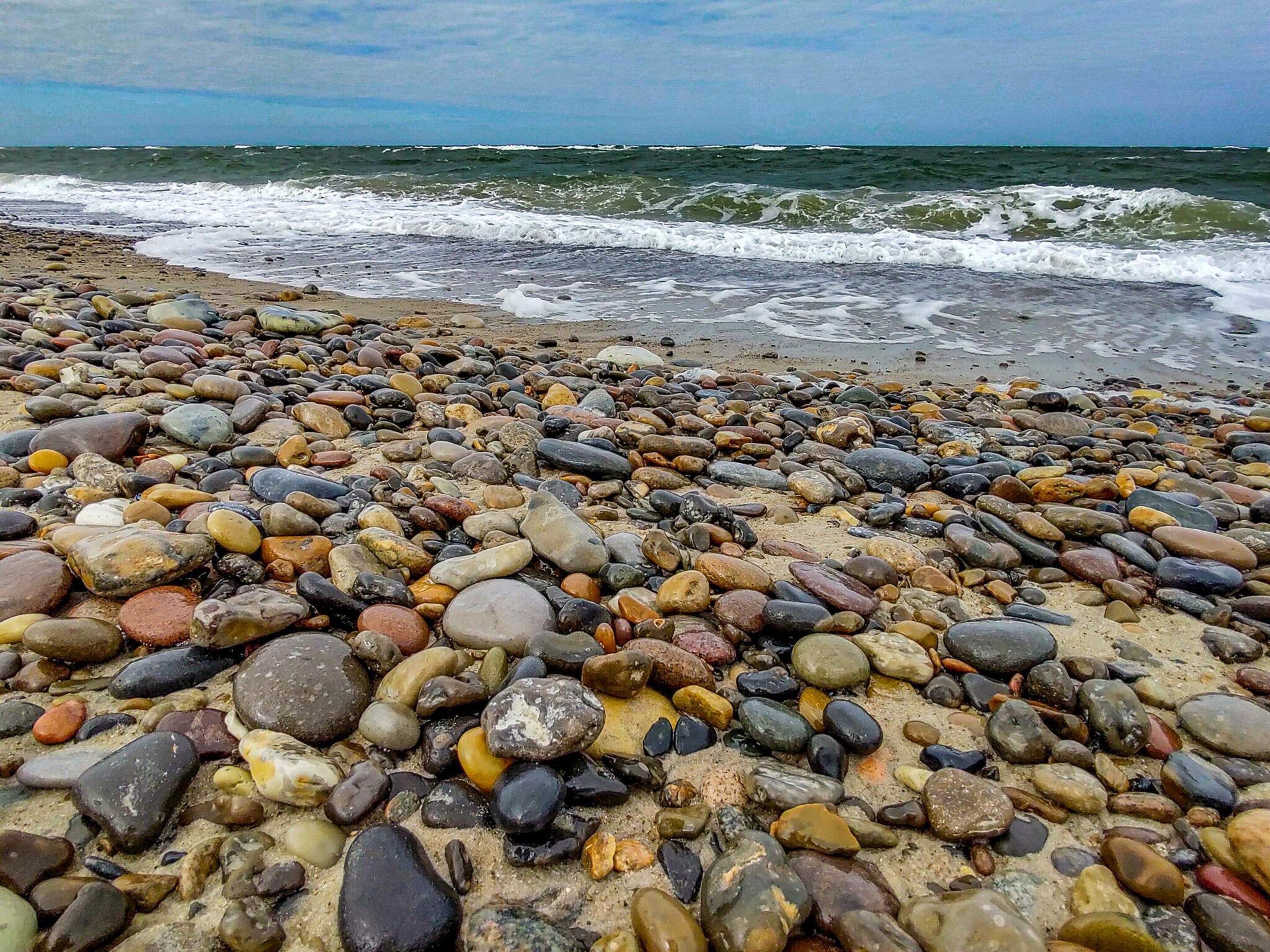 Una playa de guijarros con olas al fondo.
