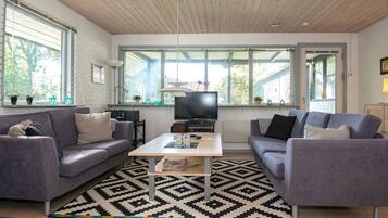 Una sala de estar moderna con un conjunto de sofá, una mesa de centro y un televisor.
