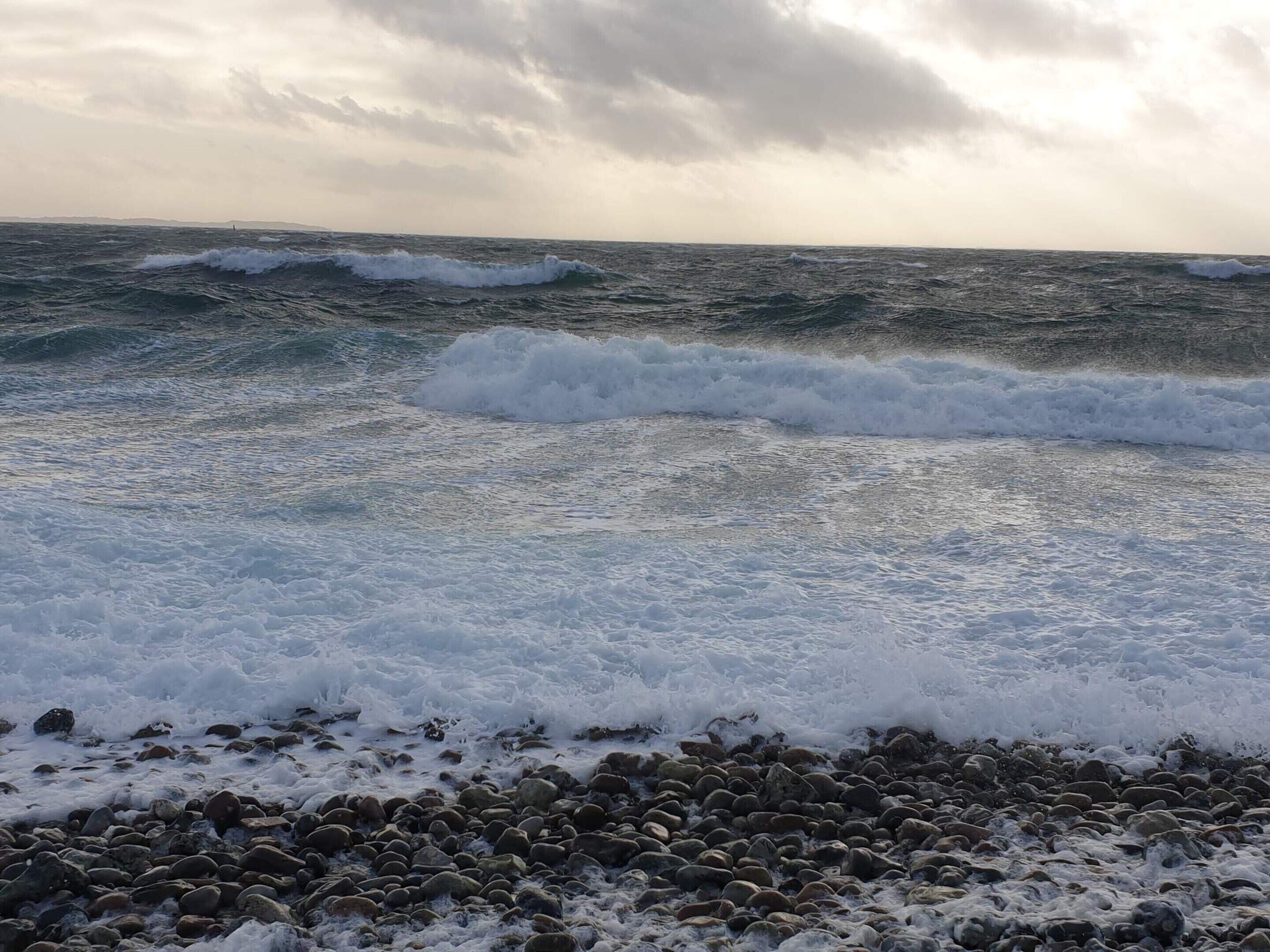 Una costa rocosa con olas rompiendo contra las rocas.