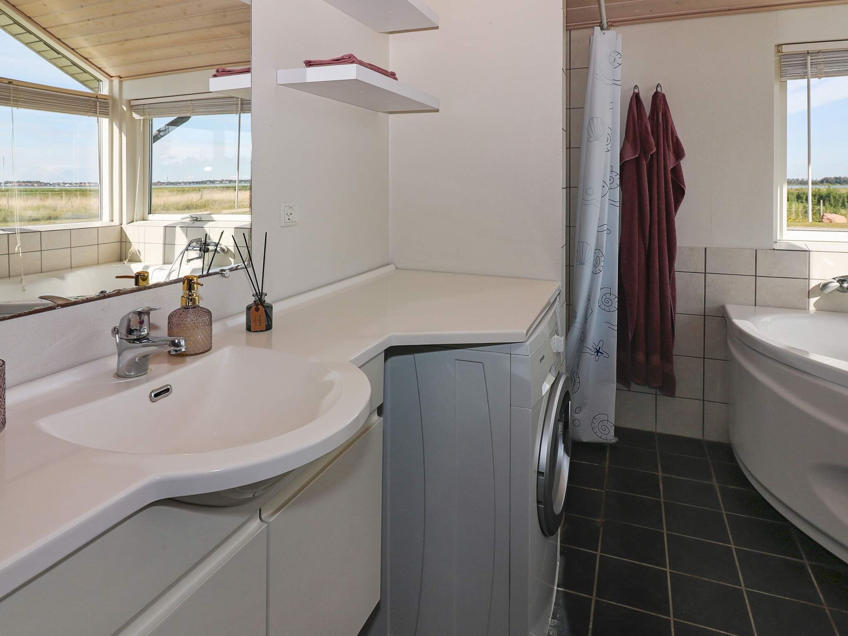A modern bathroom with a large sink, a toilet, and a shower area.