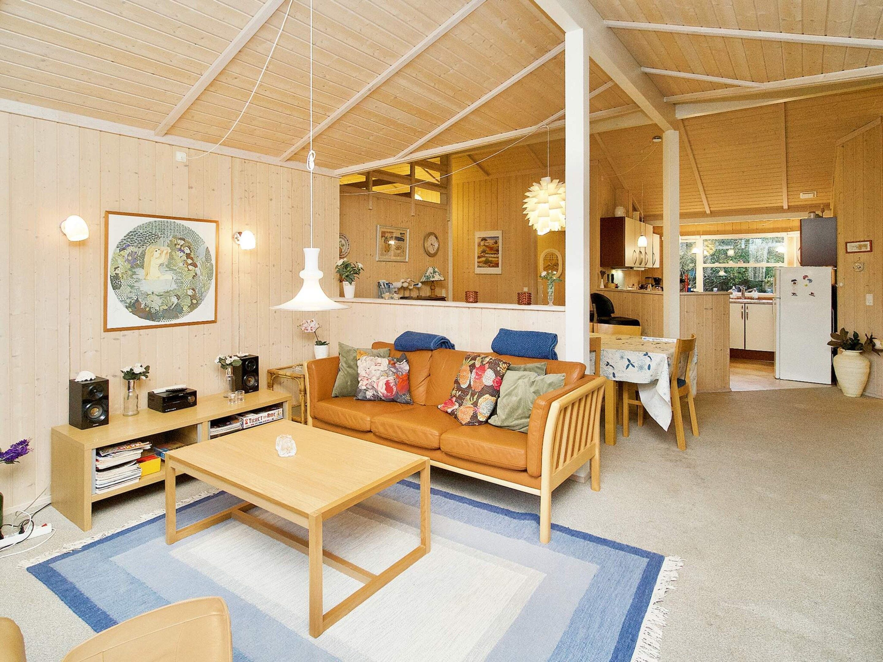 A cozy living room with a sofa, coffee table, and a dining area with a table and chairs.
