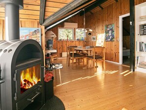 A wood-burning stove in a room with wooden walls and furniture. - 6 Person Holiday Home in Saltum (Saltum)