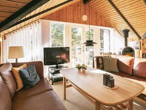 A cozy living room with a sofa, a coffee table, a television, and a fireplace. - 6 Person Holiday Home in Saltum (Saltum)