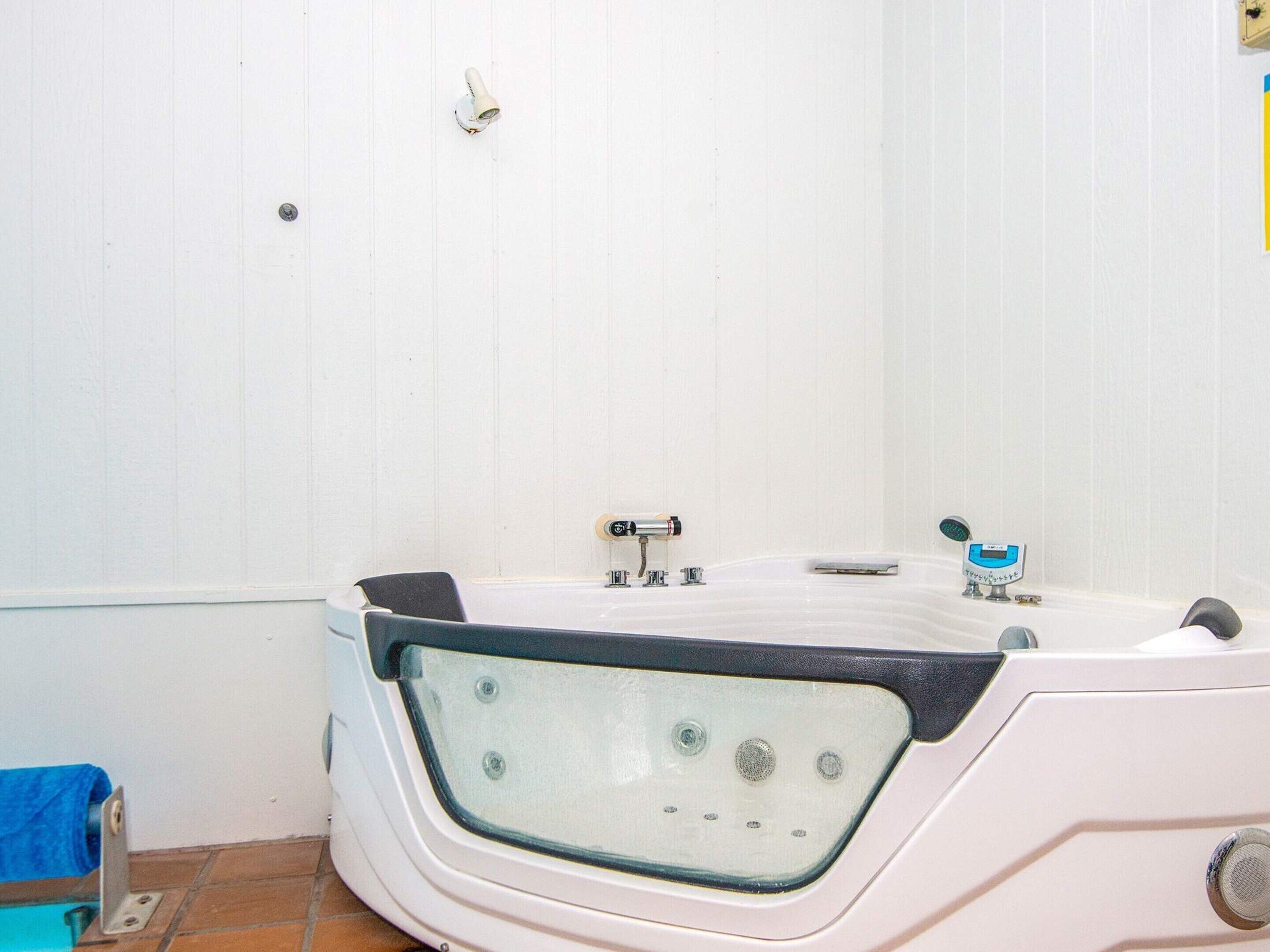 A bathroom with a white bathtub, a sink, and a shower.