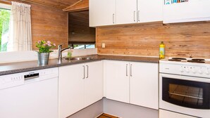 Una cucina moderna con mobili bianchi, un lavello in acciaio inox, una lavastoviglie Siemens e un forno bianco.