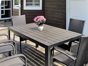 A patio with a table and chairs, a potted plant, and a door. - 5 Star Holiday Home in Hals (Hals)