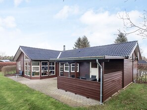 Une maison à deux étages dotée d’un patio couvert.