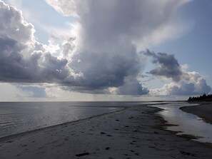 A beach with a wide sandy shore, calm water, and a partly cloudy sky. - 5 Star Holiday Home in Hals (Hals)