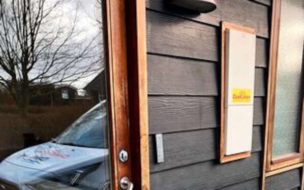 A wooden door with a window and a sign on the wall.