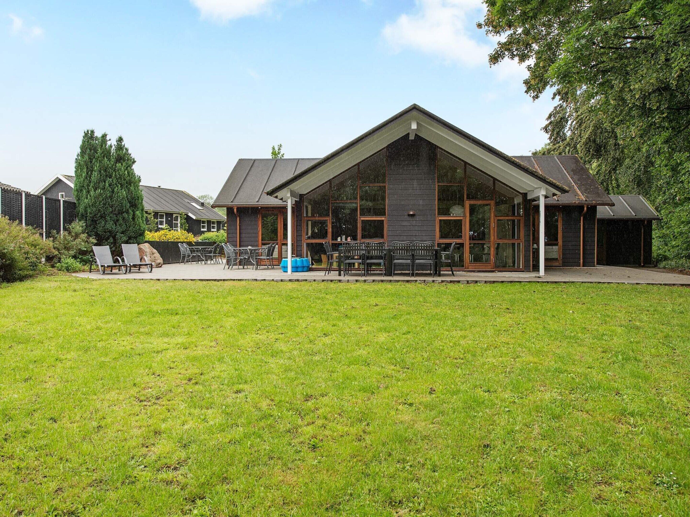 A building with a large patio area, outdoor seating, and a grassy lawn.