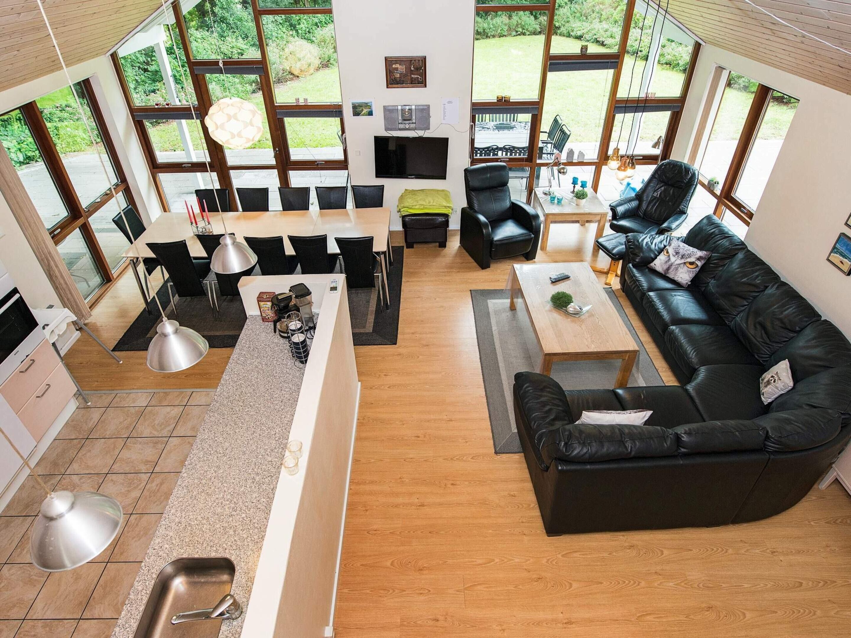 Un salon moderne comprenant un canapé, une table basse et un coin repas avec des chaises, ainsi qu’un comptoir de cuisine.