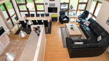 Un salon moderne comprenant un canapé, une table basse et un coin repas avec des chaises, ainsi qu’un comptoir de cuisine.
