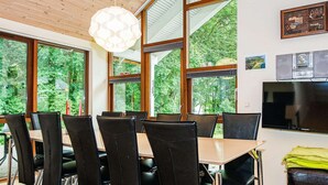 A dining area with a table, chairs, and a television. - 4 Star Holiday Home in Aabenraa (Aabenraa)