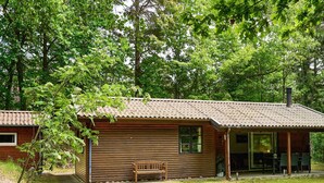 A rustic cabin with a wooden exterior, a porch, and a bench. - 6 Person Holiday Home in Ronne (Ronne)