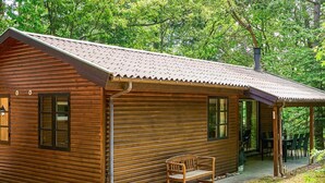 A wooden cabin with a porch, a bench, and a covered seating area. - 6 Person Holiday Home in Ronne (Ronne)