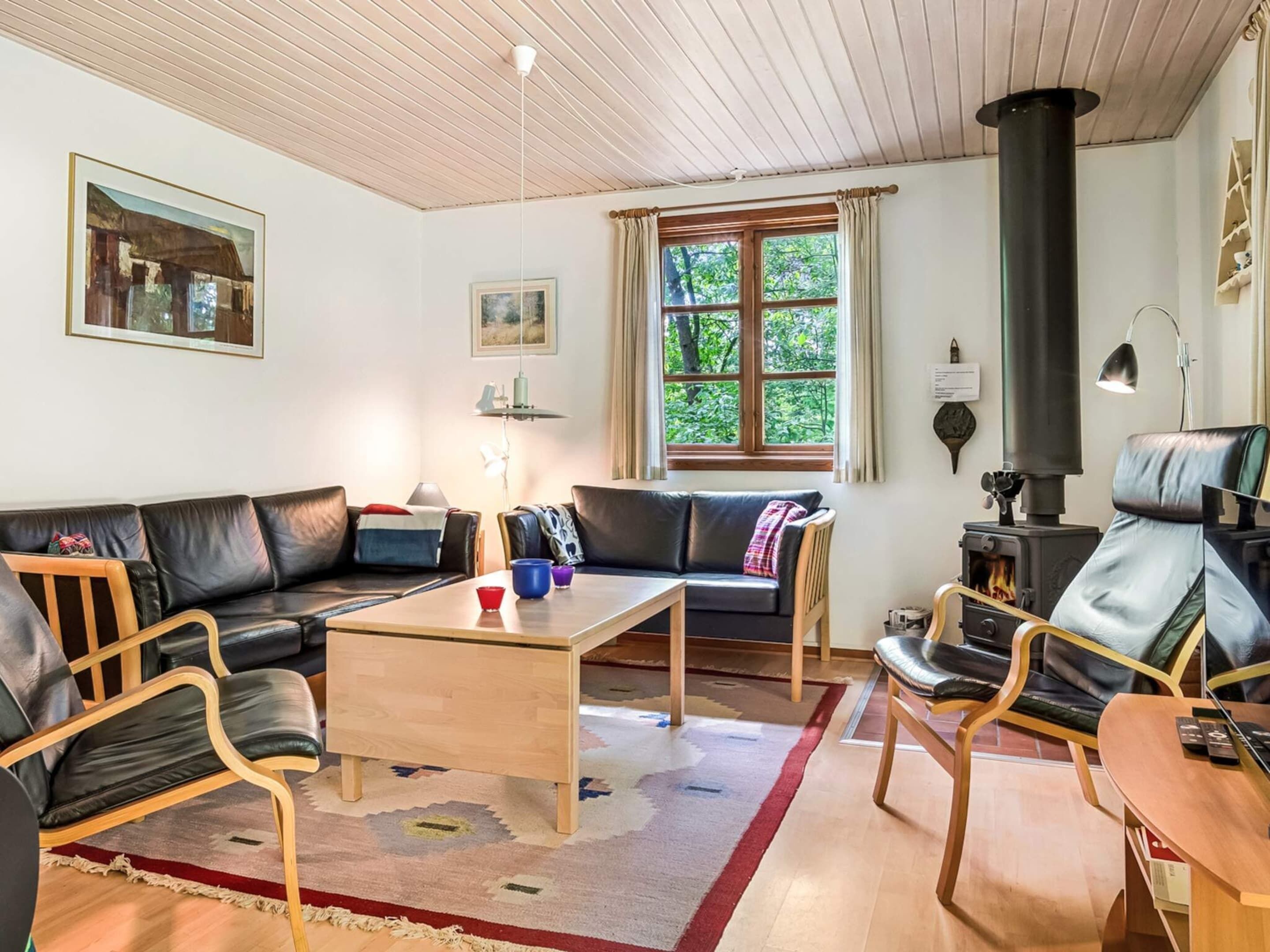 A cozy living room with a sofa, chairs, a coffee table, and a fireplace.