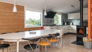 A modern kitchen with a central island, a built-in stove, and a large window providing natural light. - Spacious Cottage in Harboøre With Sauna (Harboore)