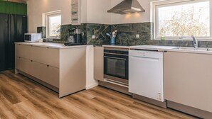 Una cocina moderna con horno empotrado, lavavajillas y microondas.
