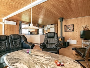 A cozy cabin interior with a dining area, a sofa, a table with candles, and a fireplace. - 6 Person Holiday Home in Hurup Thy (Hurup Thy)
