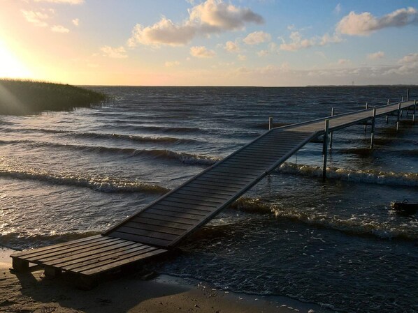 Une jetĂ©e en bois sâavançant dans lâeau, avec un banc Ă son extrĂ©mitĂ©.