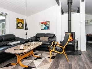 Ein modernes Wohnzimmer mit einer Couch, einem Couchtisch, einem Kamin und einem Bild an der Wand.