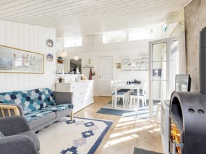 Um interior moderno com sala de estar, espaço para refeições e lareira.