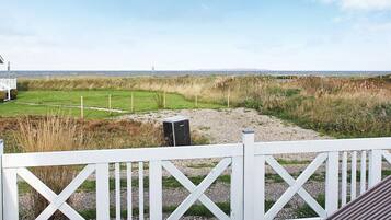 Una terraza con vistas a un campo cubierto de hierba y una costa lejana.