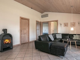 A living room with a fireplace, a sofa, a coffee table, and a door leading to another room.