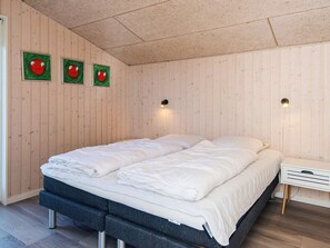 A bedroom with two beds, wooden walls, and wall-mounted lights. - 4 Star Holiday Home in Bjert (Bjert)