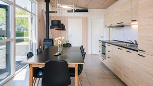 A modern kitchen with wooden cabinets, a black countertop, and a built-in oven. - 4 Star Holiday Home in Bjert (Bjert)