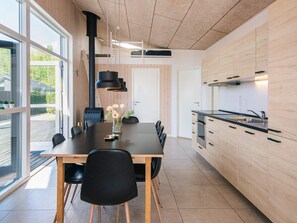 Uma cozinha moderna com armários de madeira, bancada preta e forno embutido.