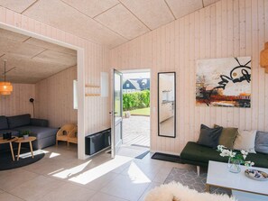Uma sala de estar moderna com um sofá, uma mesa de centro e um quadro na parede.