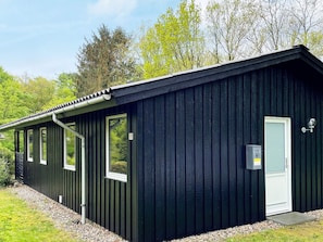 A black metal building with a door, windows, and a small outdoor area with gravel. - 6 Person Holiday Home in Toftlund (Toftlund)