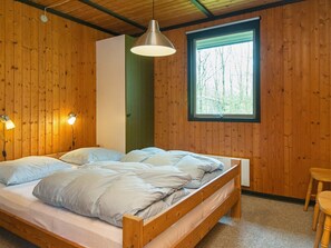 A wooden-paneled room with a bed, a window, and a hanging light fixture. - 6 Person Holiday Home in Toftlund (Toftlund)