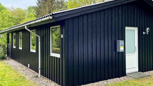 A black metal building with a door, windows, and a small outdoor area with gravel. - 6 Person Holiday Home in Toftlund (Toftlund)