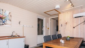 A kitchen with a wooden table, chairs, a sink, cabinets, and a window. - 6 Person Holiday Home in Tarm-by Traum (Tarm)