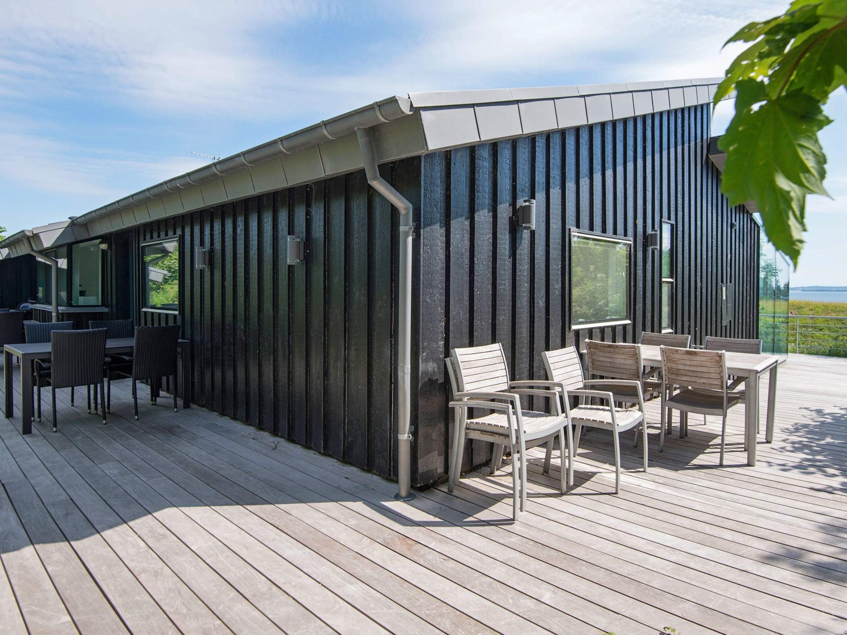 A modern outdoor seating area with a wooden deck and metal chairs.