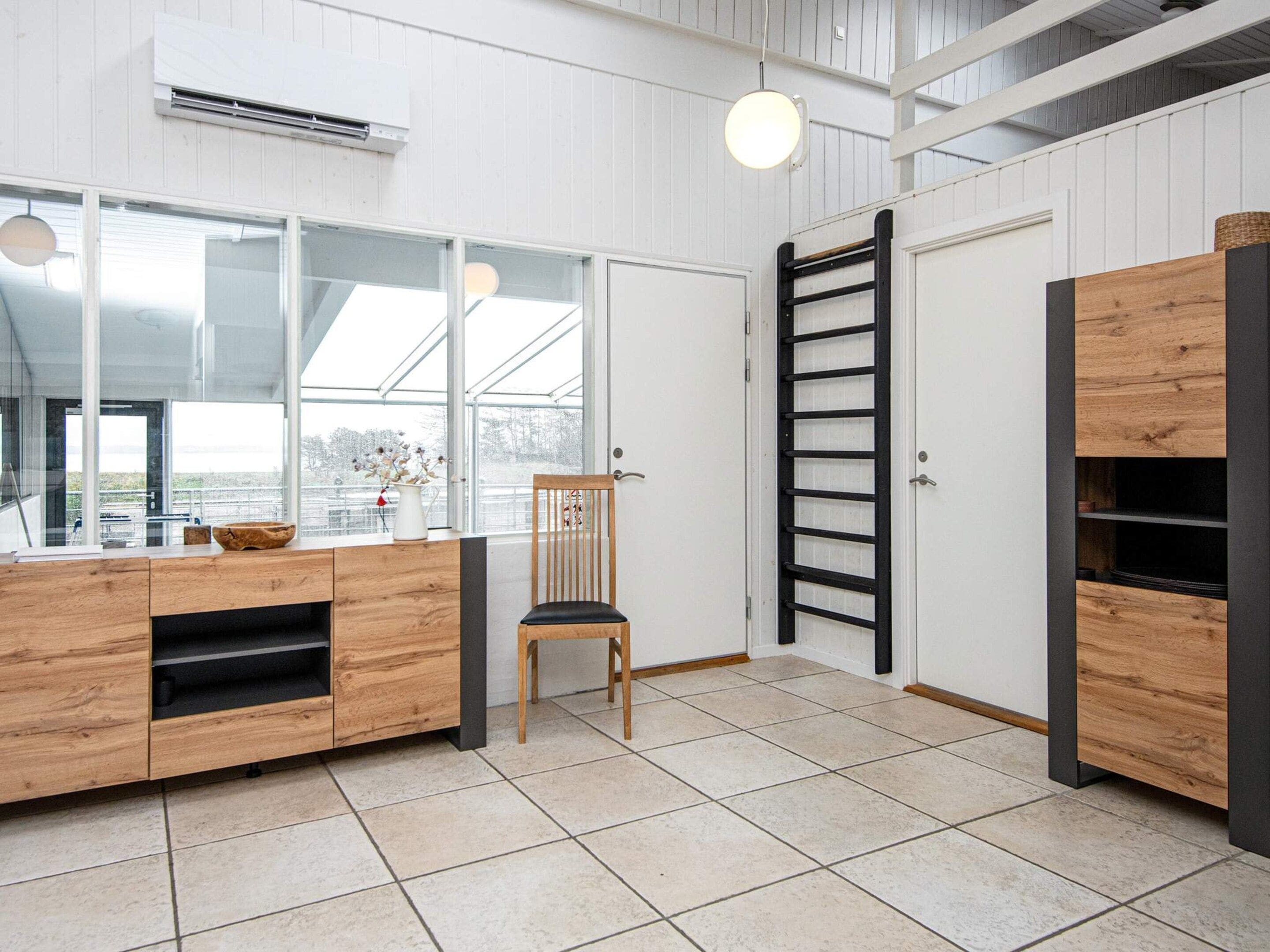Una cocina moderna con encimera de madera, una silla y una ventana con vistas.